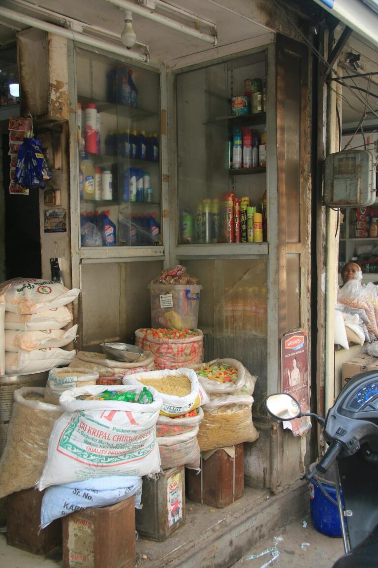 Image of a traditional Indian grocery storefront showcasing sacks of grains and products displayed outside.