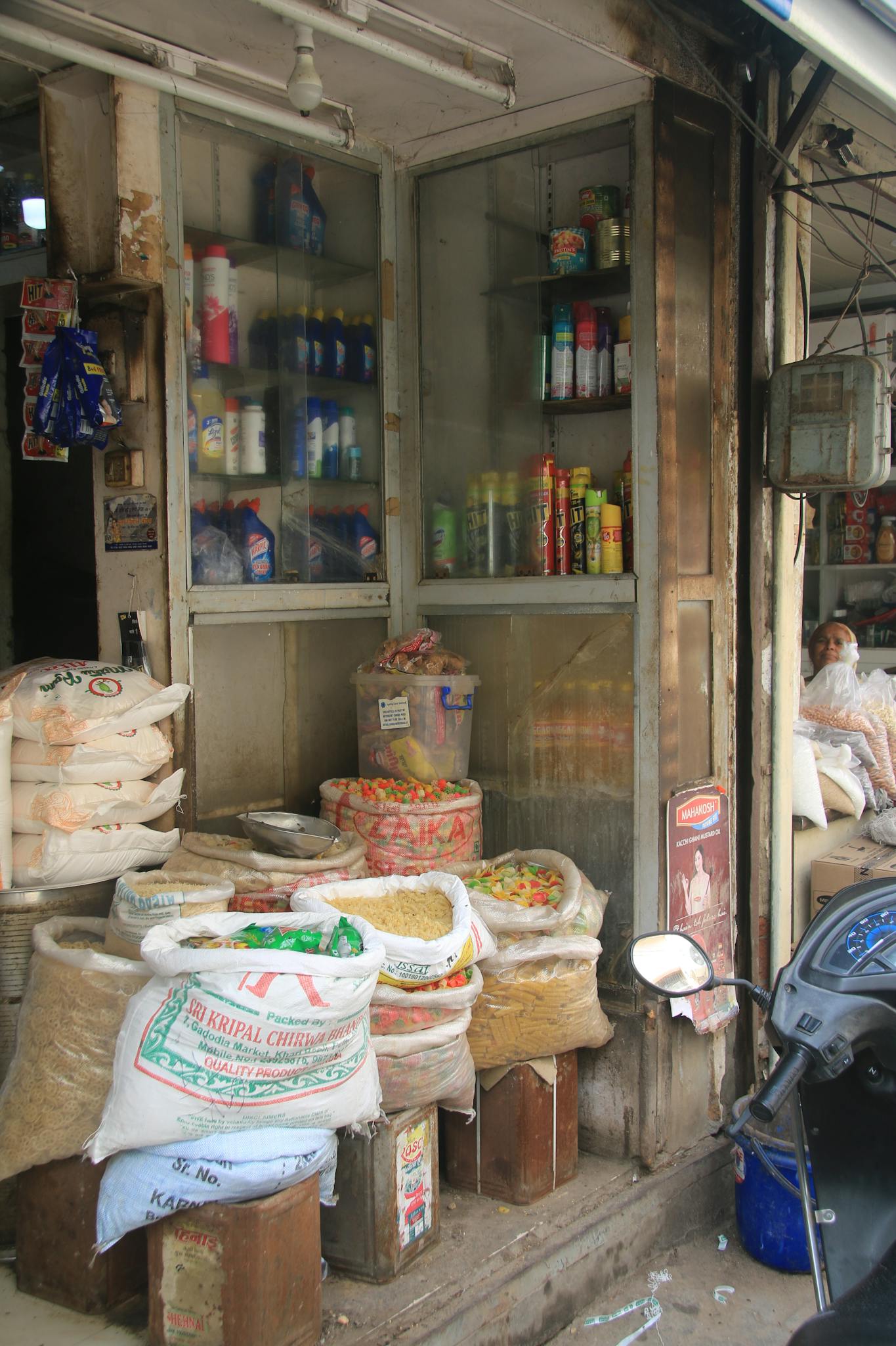 Image of a traditional Indian grocery storefront showcasing sacks of grains and products displayed outside.