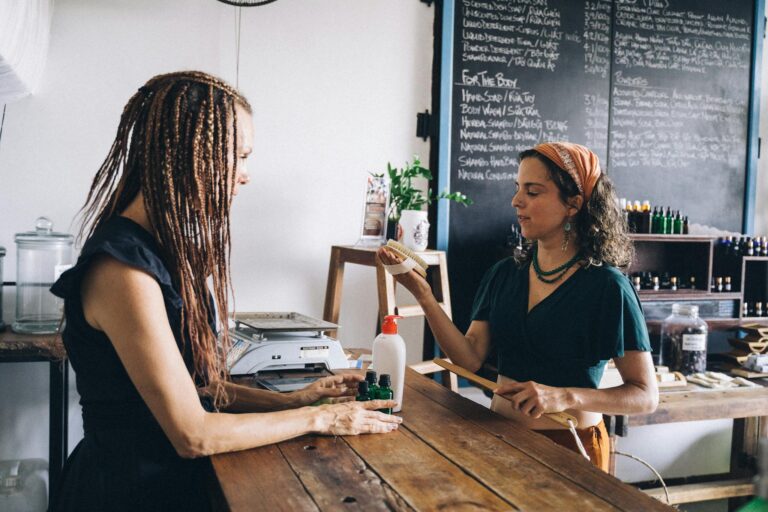 Two women interacting in an eco-friendly store, promoting organic products and sustainability.