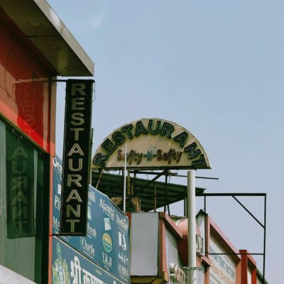 Vibrant market scene showcasing a variety of restaurant signs in India under a clear sky.
